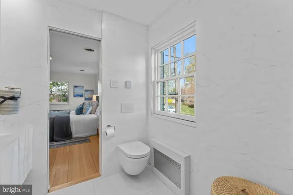 a bathroom with a toilet sink a shower and a window