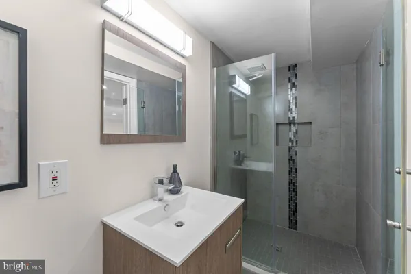 a bathroom with a sink mirror and shower