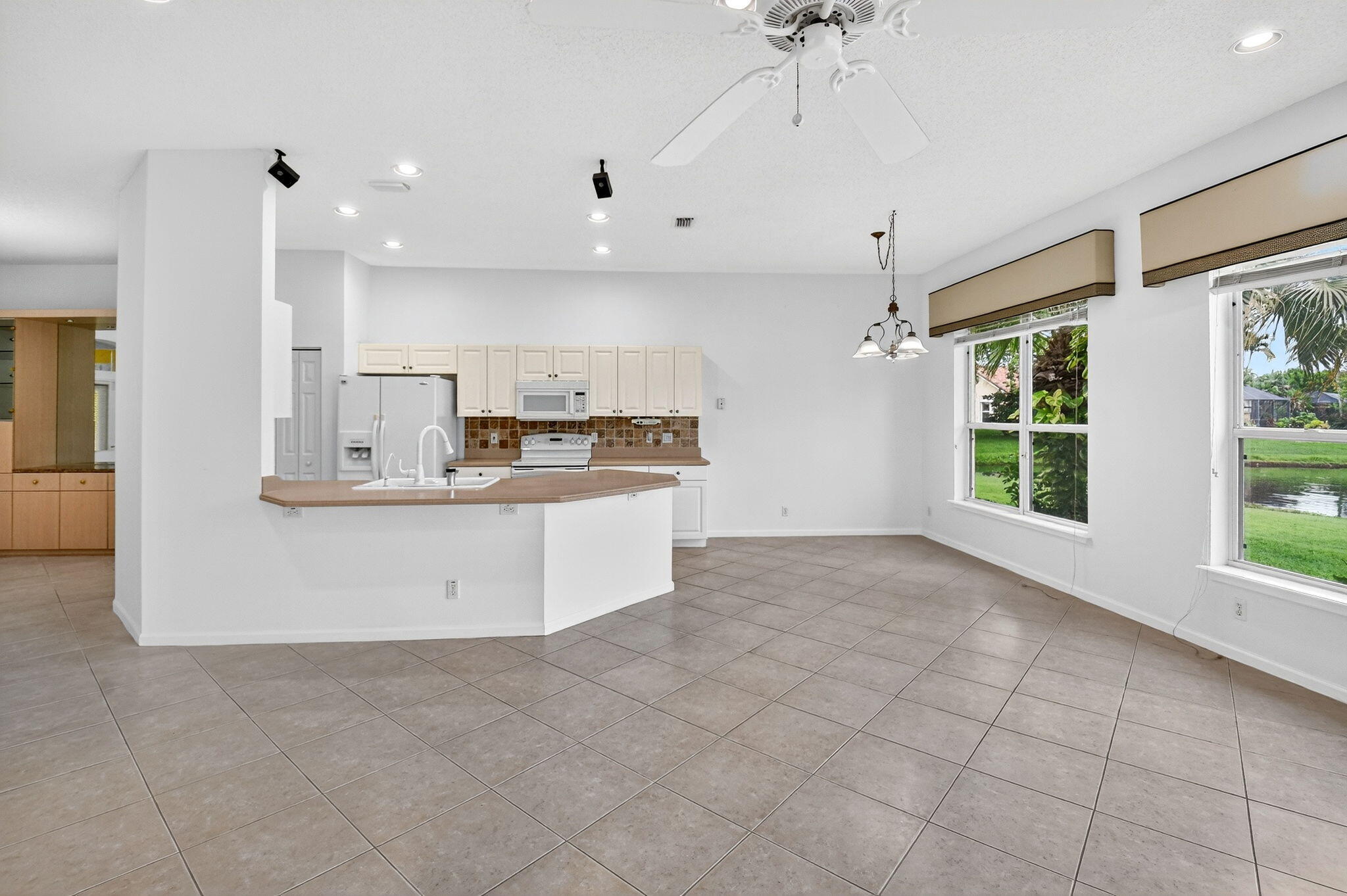 7975 Rockford Road Boynton Beach, FL 33472 - Photo 14 of 79 a large kitchen with kitchen island a large counter space a sink appliances and cabinets