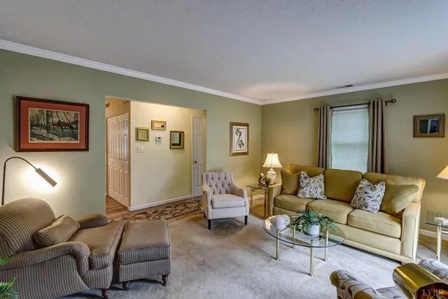 a living room with furniture a lamp on walls and a window