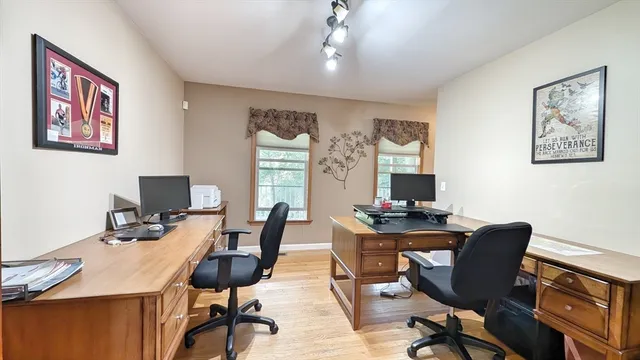 a view of a workspace with furniture and a window