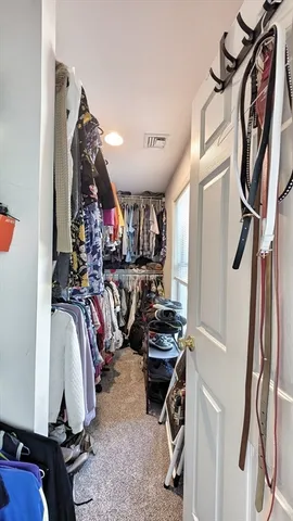 a view of walk in closet with clothes and shoes