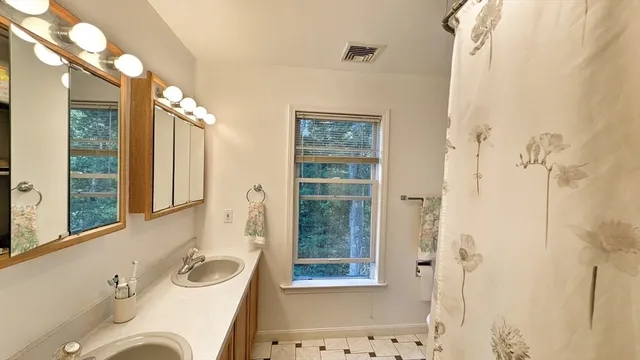a bathroom with a tub sink and mirror
