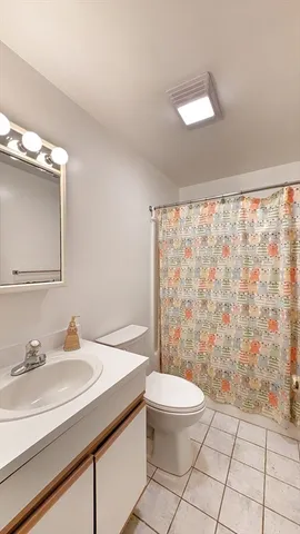 a bathroom with a sink a toilet a mirror and shower