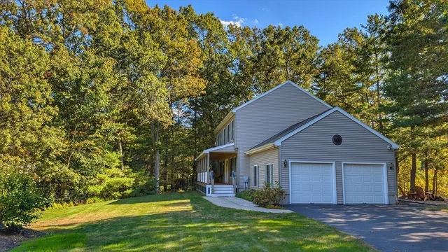 a front view of house with yard and trees in the background