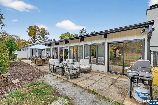 a view of a house with backyard and sitting area
