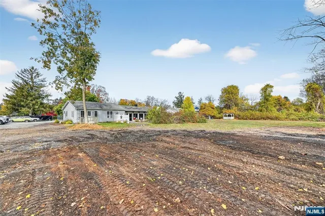 a view of a house with a big yard and large trees
