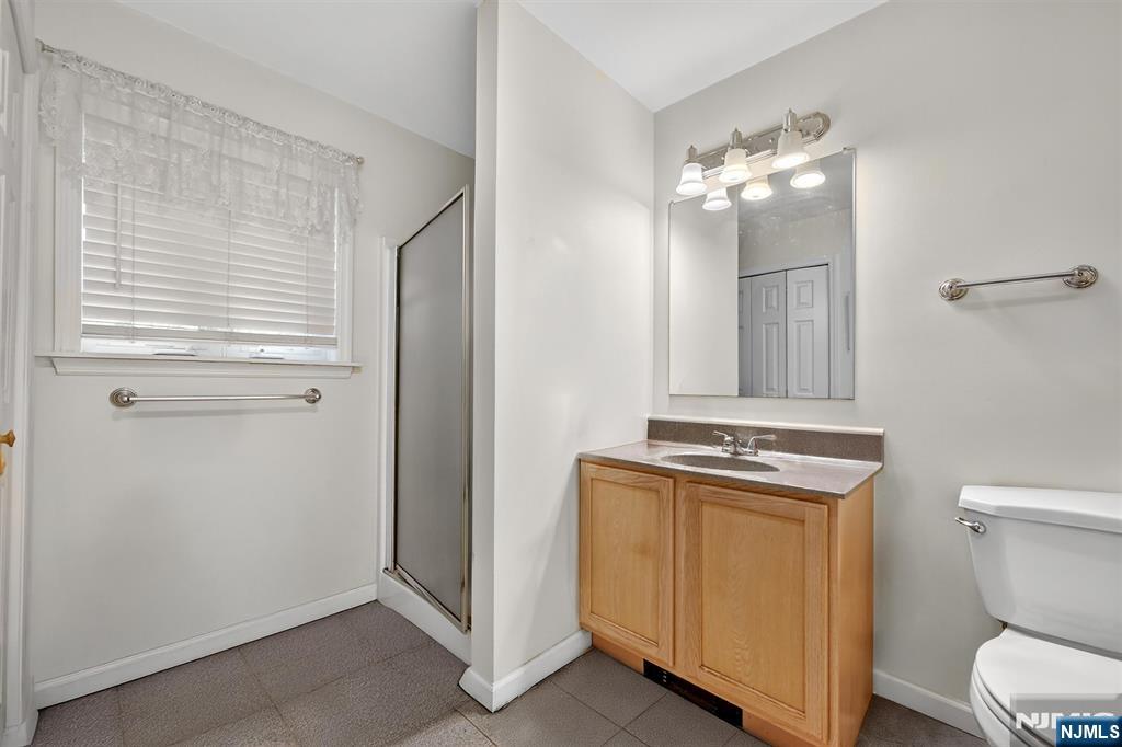 13 Main Street Paterson, NJ 07503 - Photo 7 of 46 a bathroom with a toilet a sink and mirror
