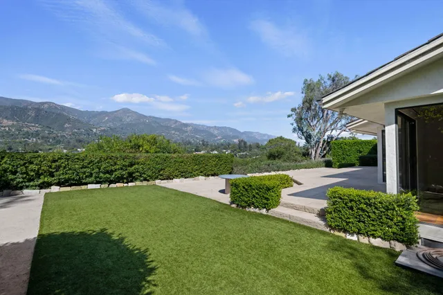 a view of a house with garden and a yard