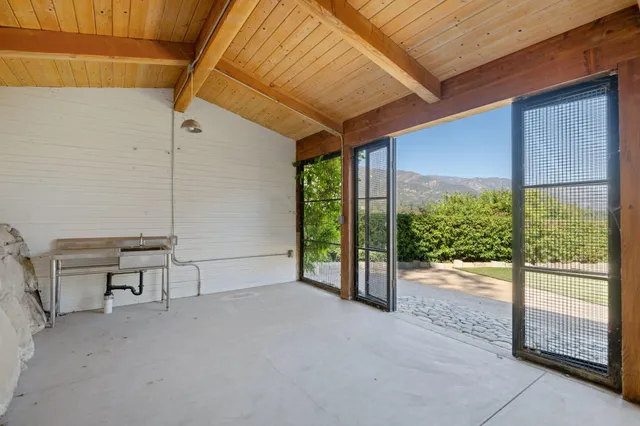 a view of a patio with table and chairs and floor to ceiling window