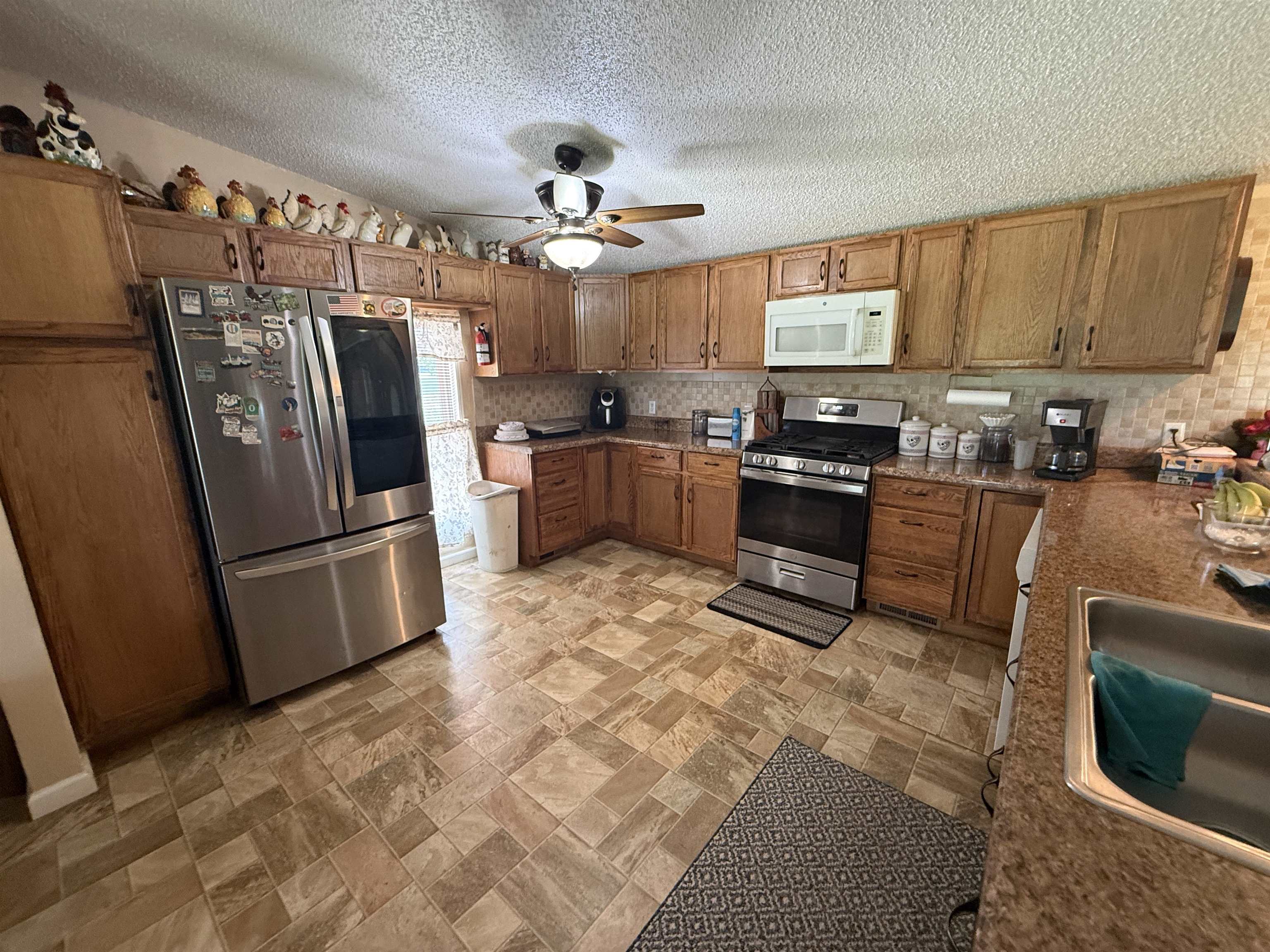 2201 Robert Johnson Road Covington, TN 38019 - Photo 13 of 25 Kitchen featuring wood cabinetry, stainless steel appliances, and patterned flooring