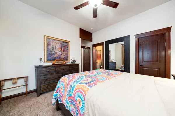 a bedroom with a bed and a dresser with wooden floor
