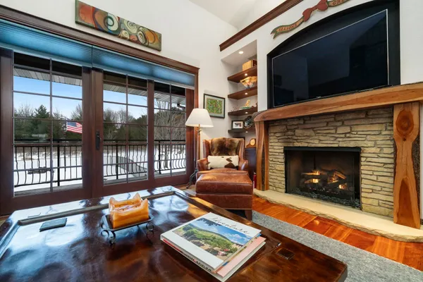 a living room with furniture a flat screen tv and a refrigerator
