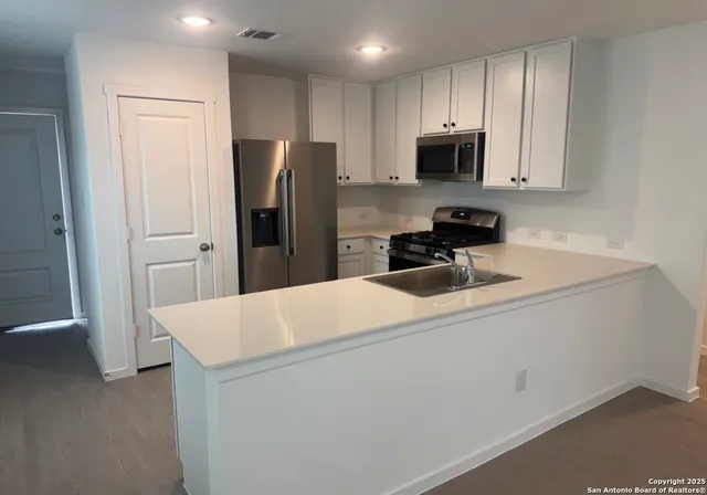 a kitchen with a refrigerator a stove and a sink