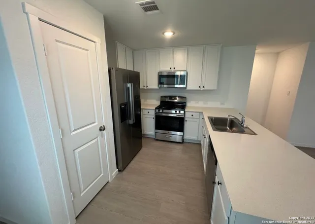 a kitchen with a refrigerator a stove top oven a sink and dishwasher