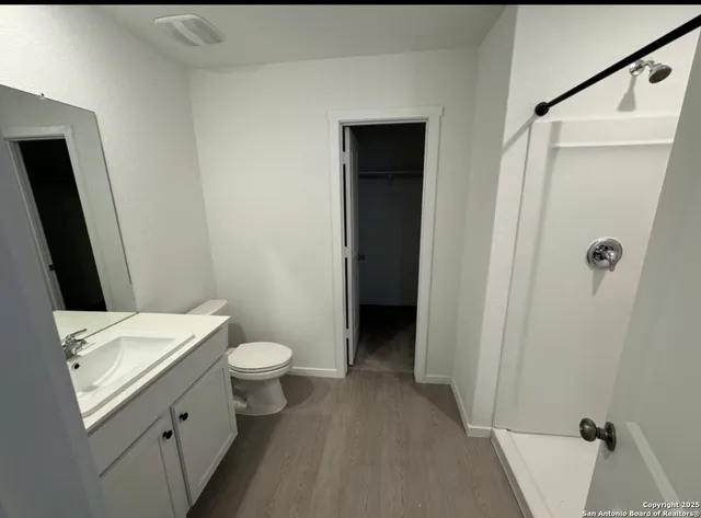 a bathroom with a granite countertop sink toilet and shower