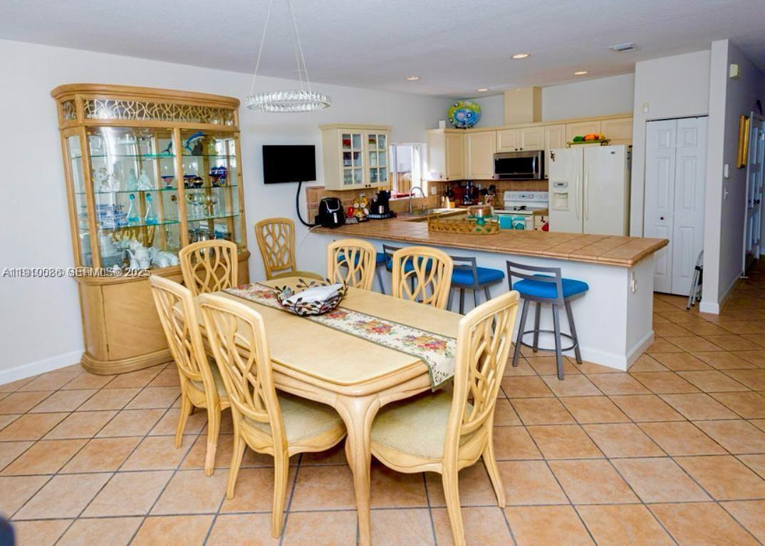 14241 Southwest 129th Avenue Miami, FL 33186 - Photo 12 of 24 a dining room with furniture and wooden floor