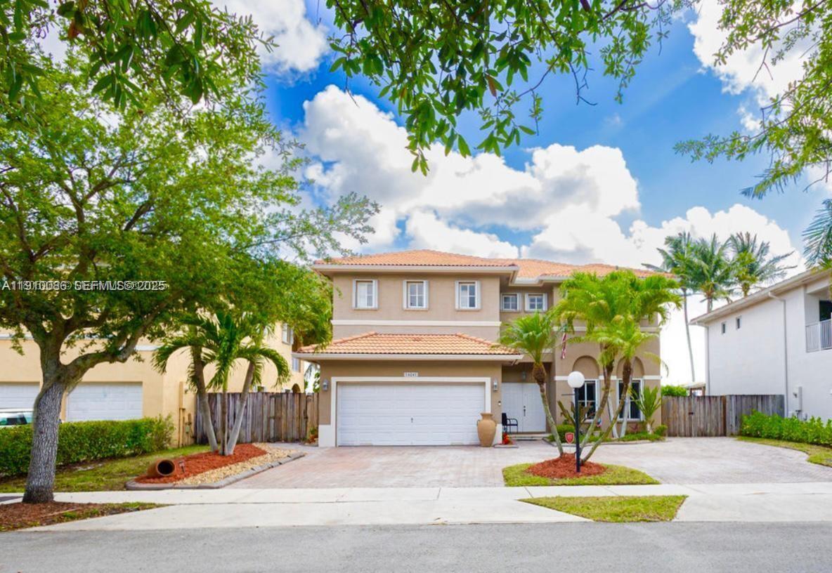 14241 Southwest 129th Avenue Miami, FL 33186 - Photo 4 of 24 a front view of a house with a yard and garage