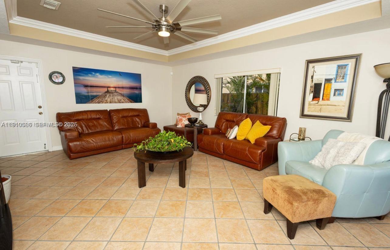 14241 Southwest 129th Avenue Miami, FL 33186 - Photo 8 of 24 a living room with furniture ceiling fan and a rug