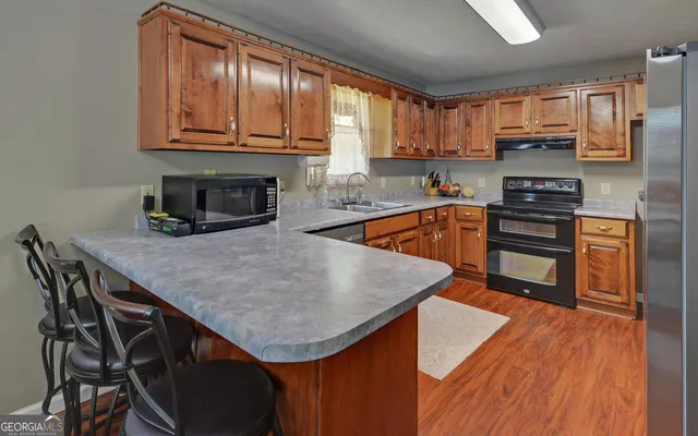 a kitchen with stainless steel appliances granite countertop a stove a sink and a microwave