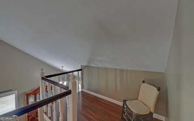 a view of a hallway with furniture and wooden floor