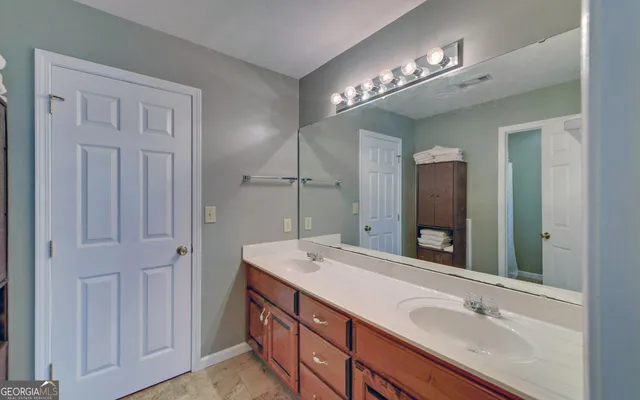 a bathroom with double vanity sink and a mirror