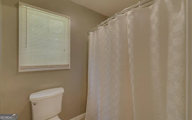 a white toilet sitting next to a shower curtain