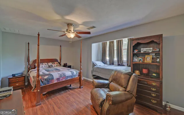 a bedroom with furniture and wooden floor