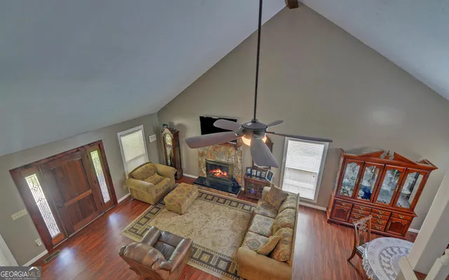 a living room with furniture a fireplace and wooden floor