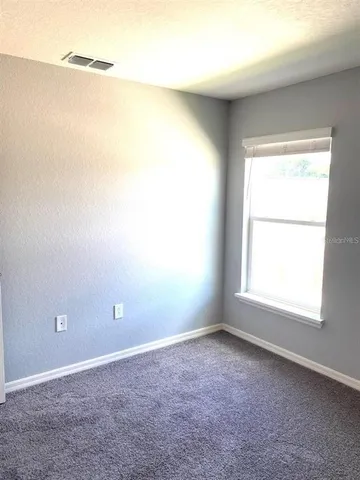 a bedroom with a bed and painting on the wall