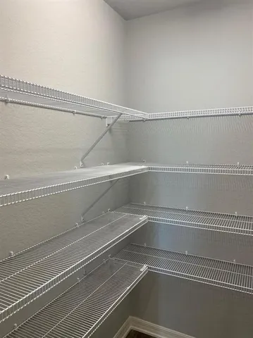 a bedroom with a bed lamp and a large window