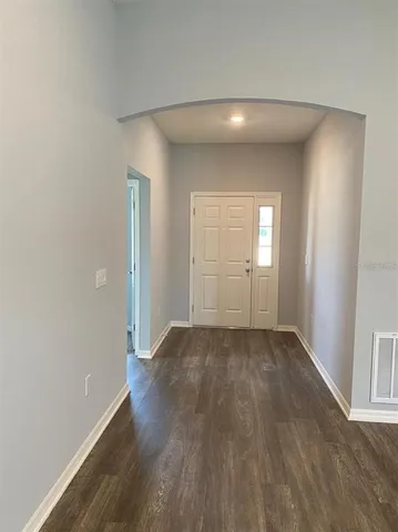 an empty room with wooden floor and mirror