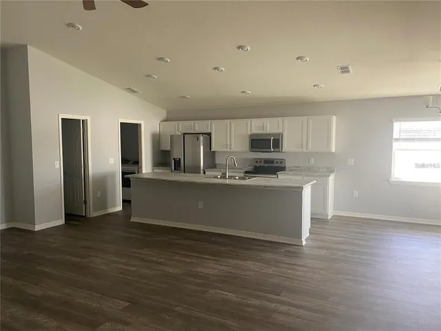 a kitchen with stainless steel appliances a refrigerator sink and cabinets
