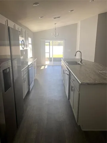 a kitchen with sink a refrigerator and window