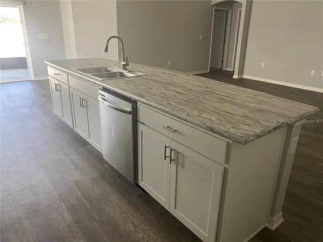 a view of a sink a faucet a mirror and cabinets
