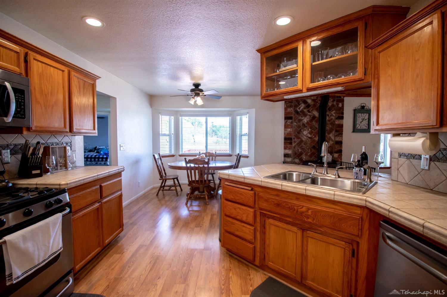 21209 Ridgeway Drive Tehachapi, CA 93561 - Photo 8 of 50 a kitchen with a sink appliances wooden floor and a window