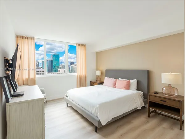 a bedroom with a bed and a large window