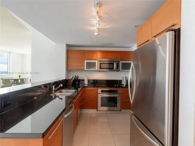 a kitchen with stainless steel appliances granite countertop a refrigerator and a sink