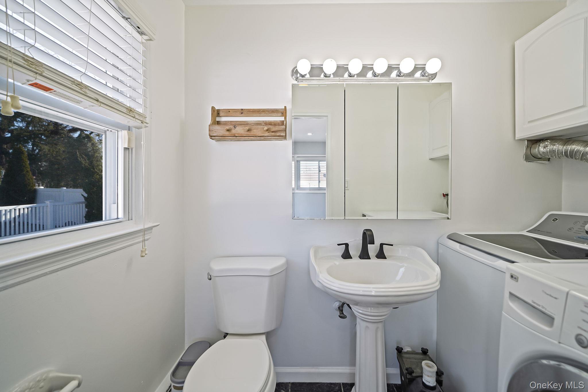 2415 Babylon Turnpike Merrick, NY 11566 - Photo 15 of 32 a bathroom with a sink a mirror and a toilet