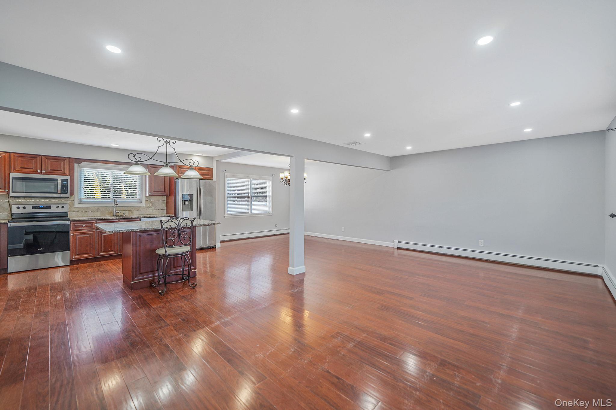 2415 Babylon Turnpike Merrick, NY 11566 - Photo 4 of 32 a view of a living room and kitchen with furniture wooden floor