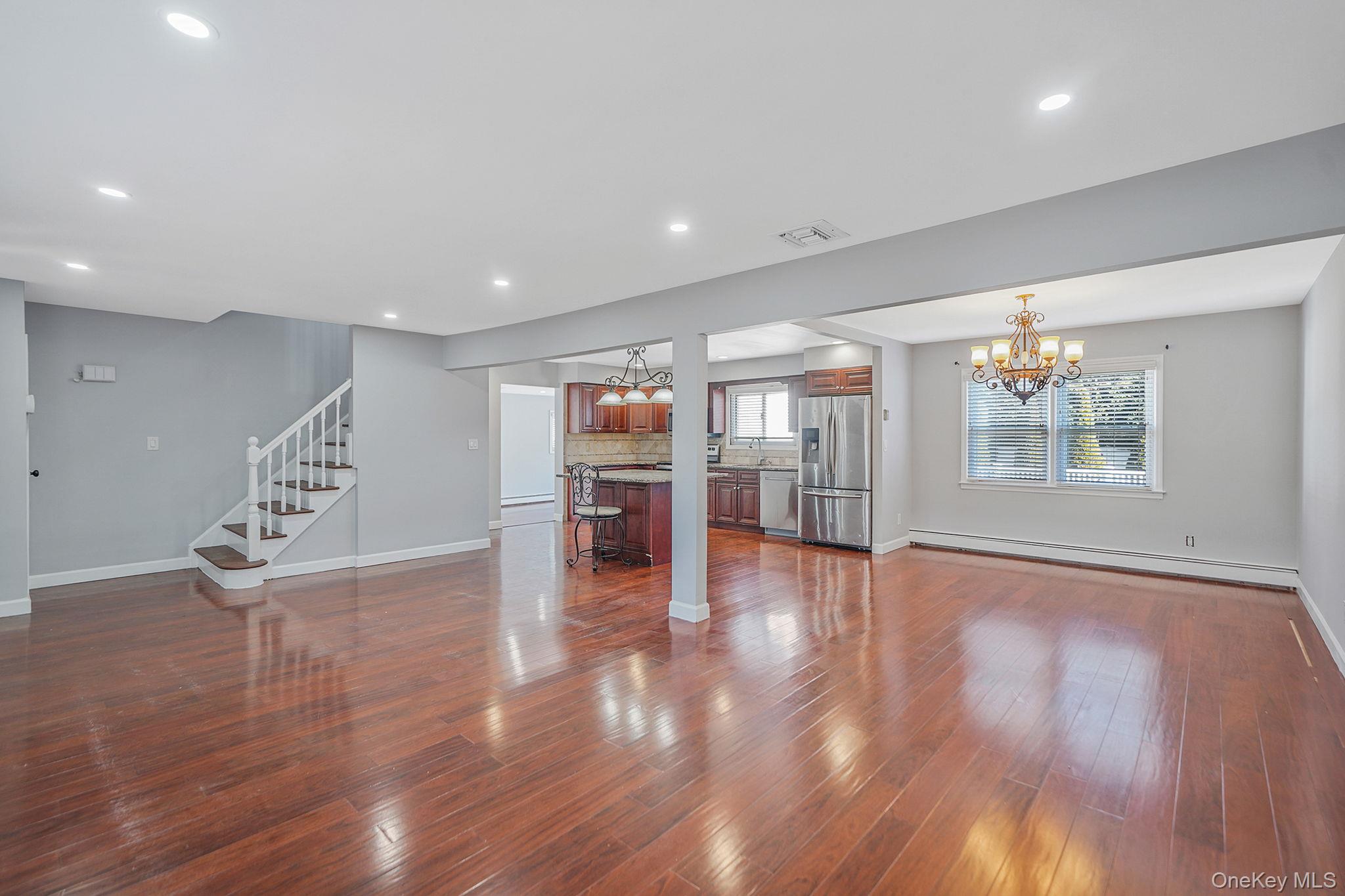 2415 Babylon Turnpike Merrick, NY 11566 - Photo 6 of 32 a view of an empty room with wooden floor and a window