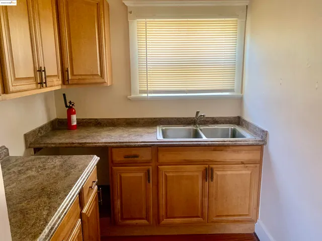 a sink sitting inside of a kitchen with granite countertop cabinets