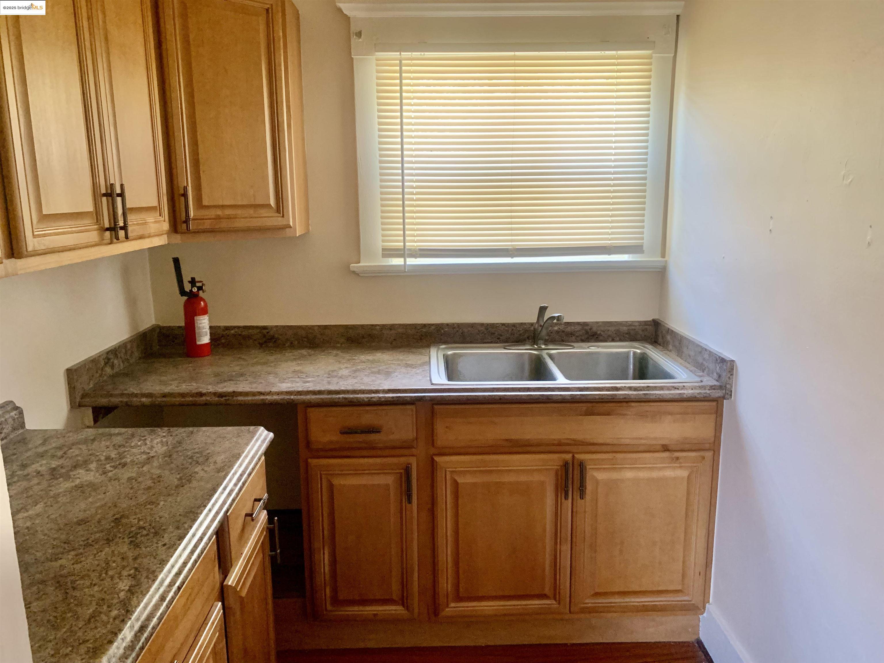 1028 61st Street Oakland, CA 94608 - Photo 15 of 28 a sink sitting inside of a kitchen with granite countertop cabinets