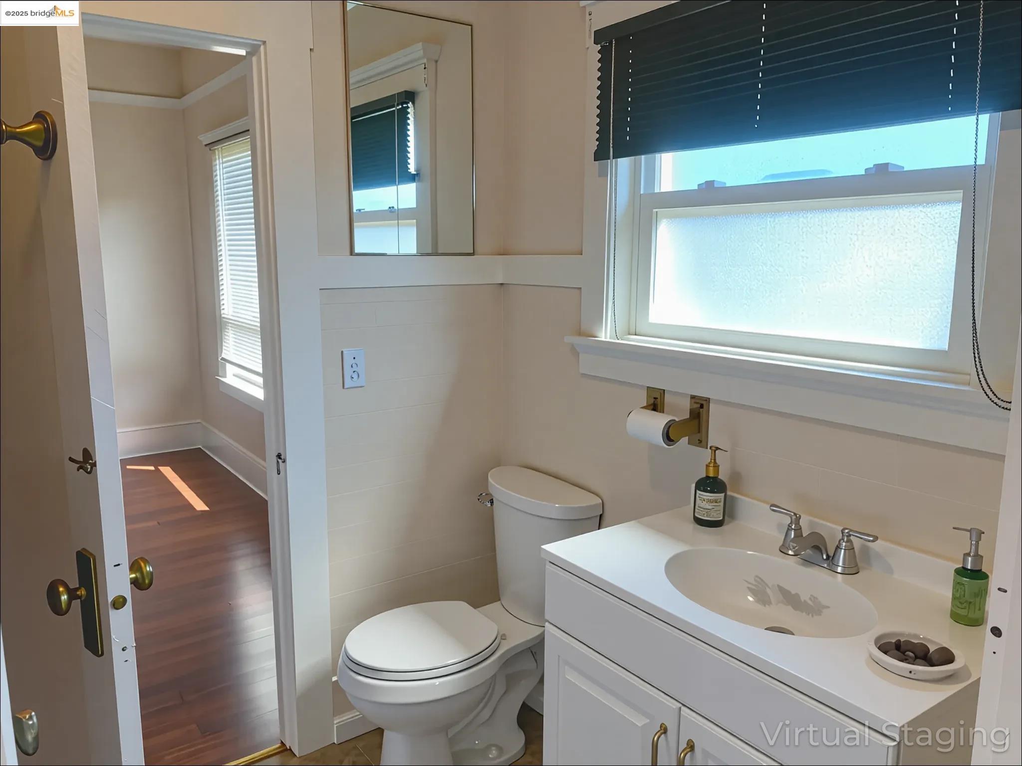 1028 61st Street Oakland, CA 94608 - Photo 16 of 28 a bathroom with a sink toilet and mirror