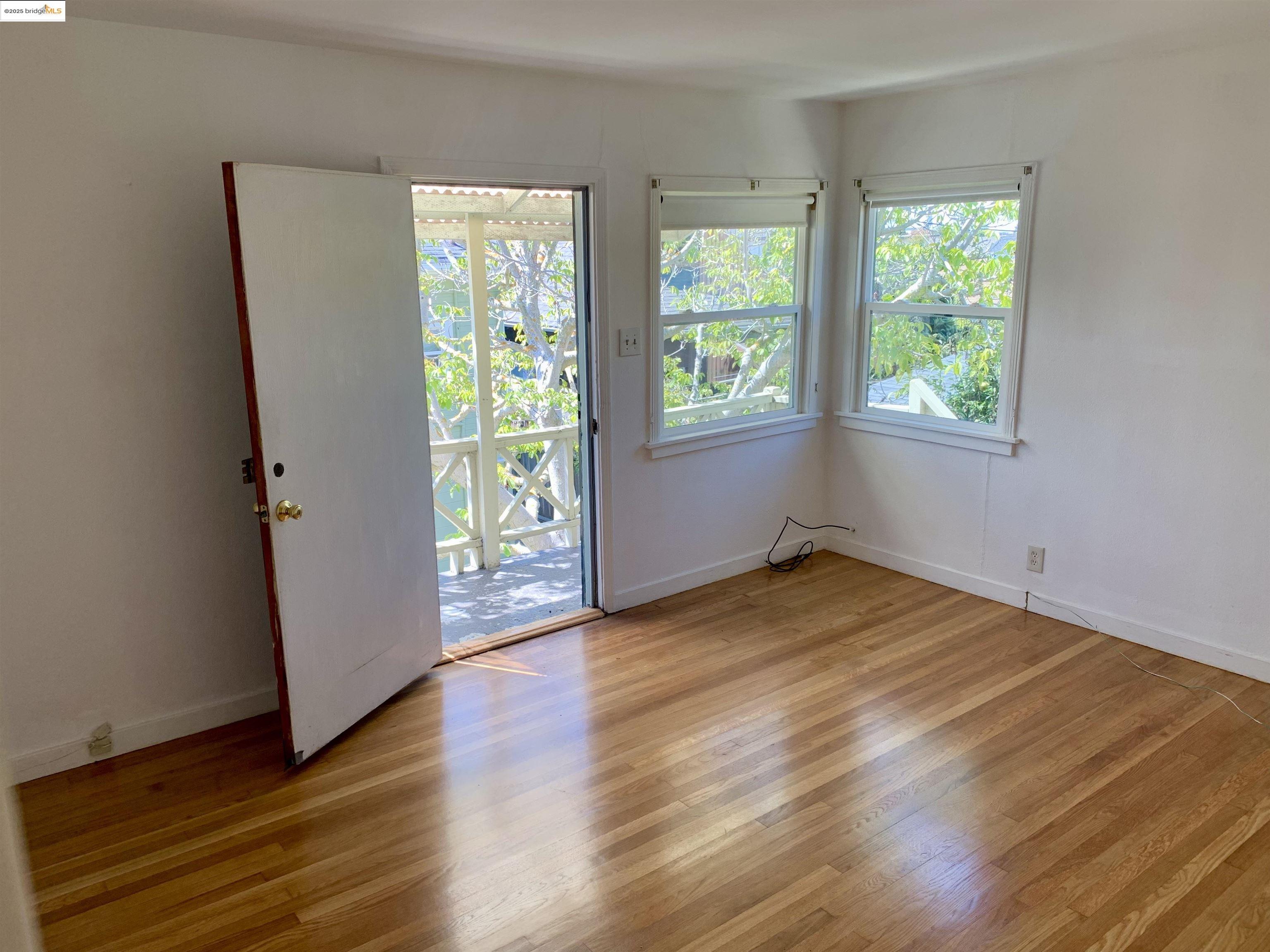 1028 61st Street Oakland, CA 94608 - Photo 20 of 28 a view of an empty room with wooden floor and a window