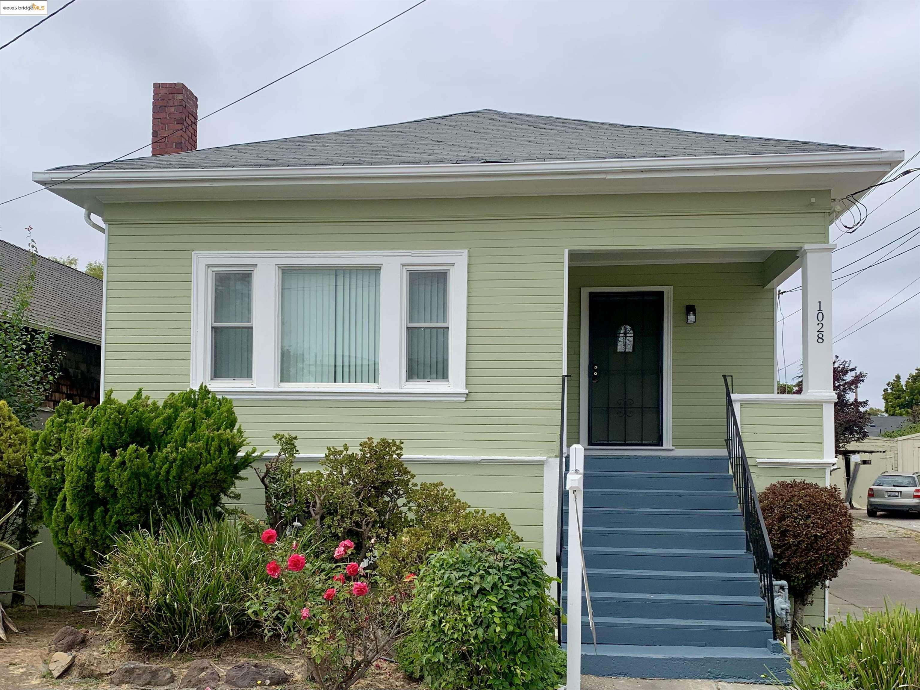 1028 61st Street Oakland, CA 94608 - Photo 2 of 28 a front view of a house with potted plants