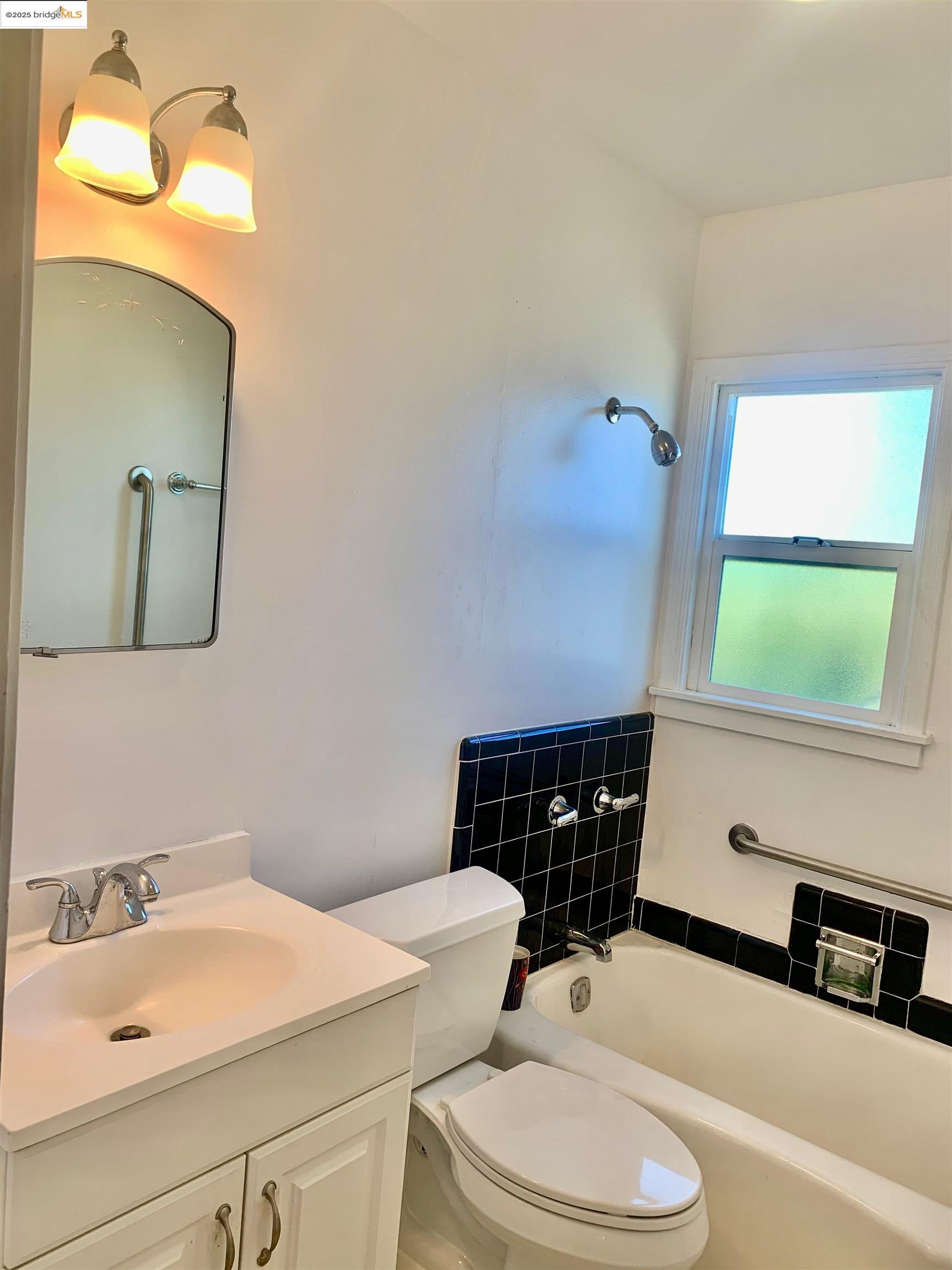 1028 61st Street Oakland, CA 94608 - Photo 22 of 28 a bathroom with a sink a toilet and mirror