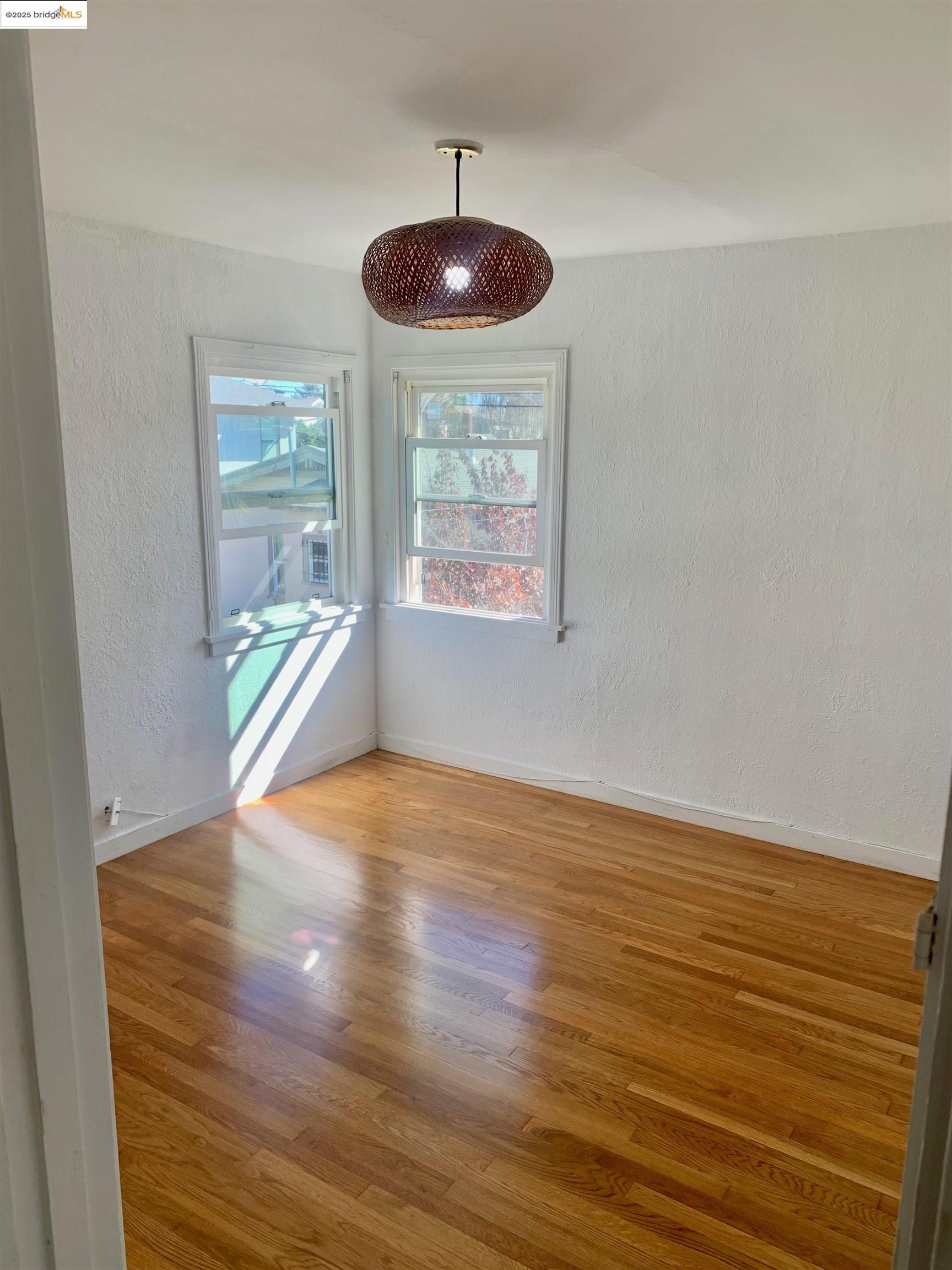 1028 61st Street Oakland, CA 94608 - Photo 25 of 28 an empty room with wooden floor and windows