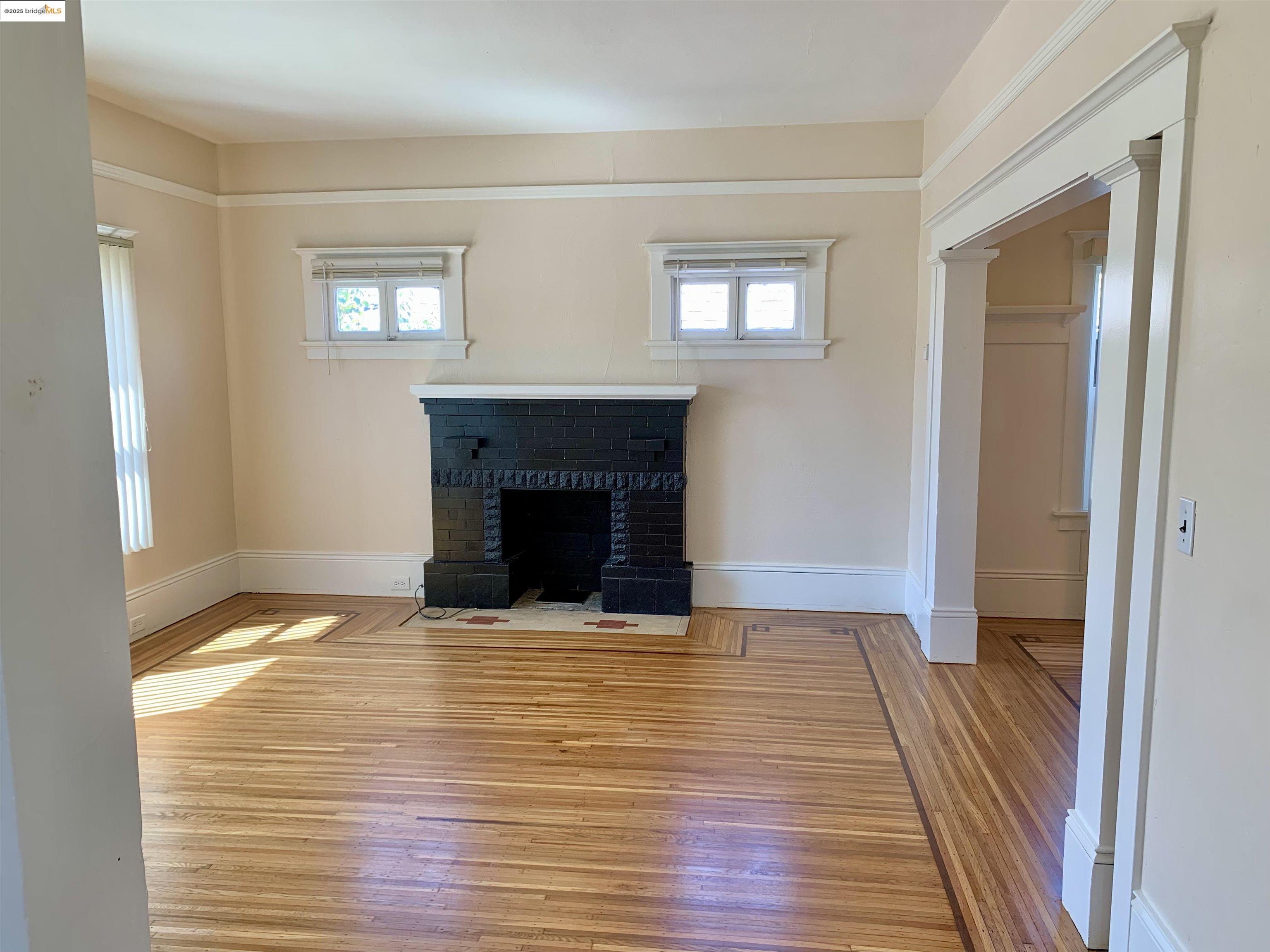1028 61st Street Oakland, CA 94608 - Photo 5 of 28 a view of empty room with wooden floor and fireplace