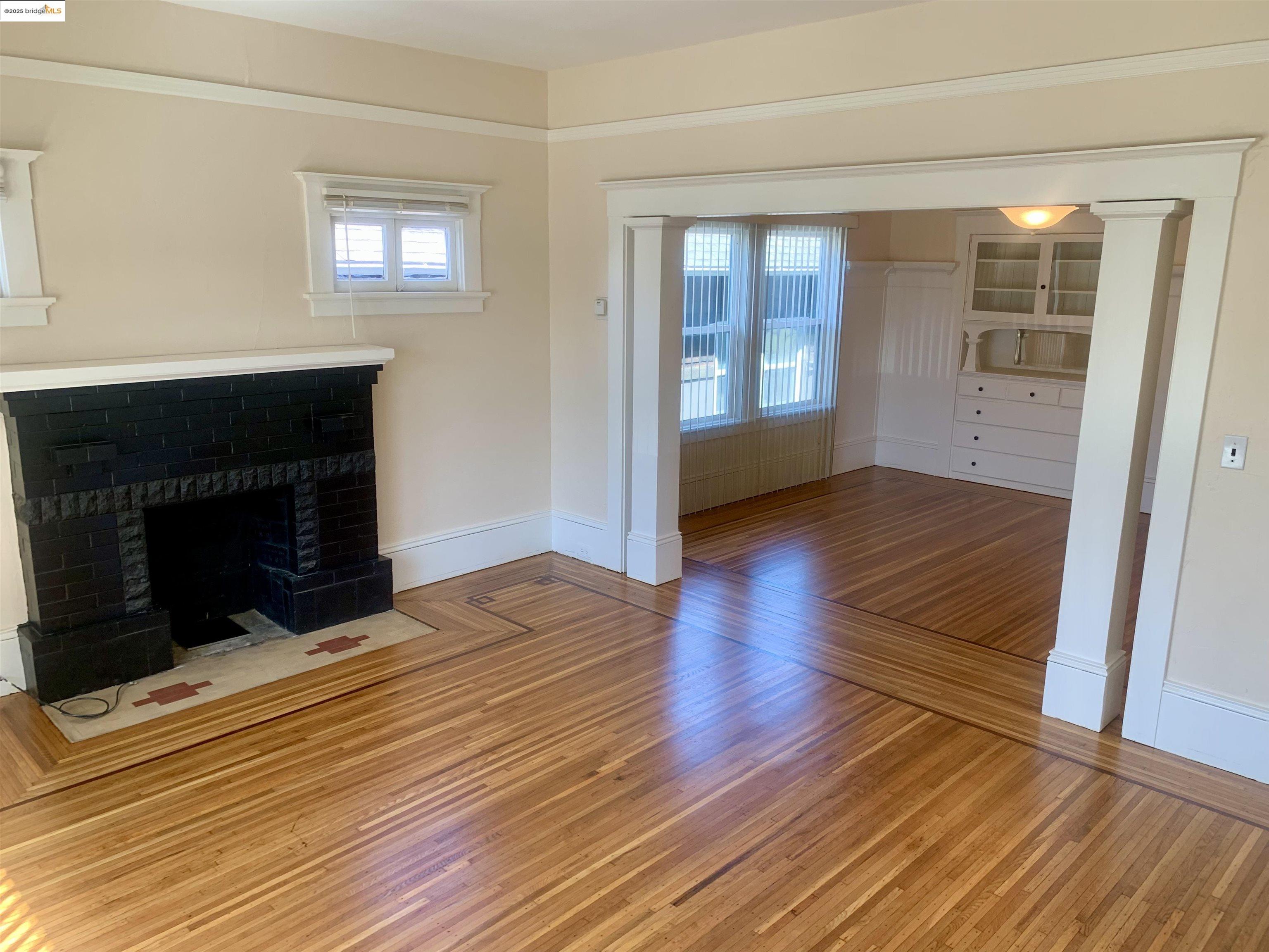1028 61st Street Oakland, CA 94608 - Photo 6 of 28 a living room with wooden floors and a fireplace